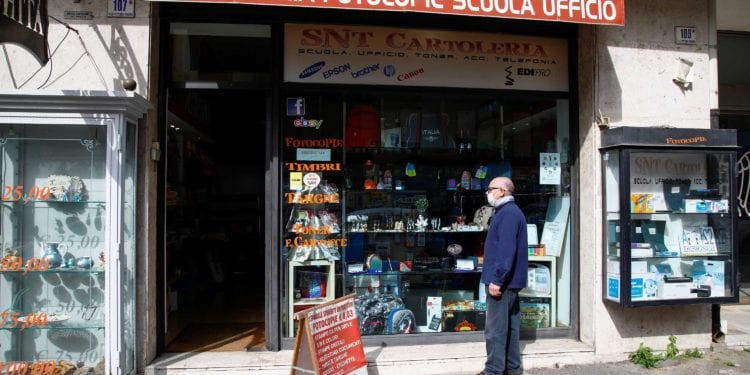 A man wearing a face mask stands in front of the store as the Italian government allows the reopening of some shops while a nationwide lockdown continues, following the outbreak of coronavirus disease (COVID-19) in Catania, Italy, April 14, 2020. REUTERS/Antonio Parrinello