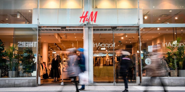 Shoppers walk past a fashion store of H&M (H & M Hennes & Mauritz AB) in central Stockholm on April 2, 2020. - Swedish retailer H&M said that the company have started dialogue with tens of thousands of staff about cutting working hours due to the coronavirus (Covid-19) pandemic effect on the market. (Photo by Fredrik SANDBERG / various sources / AFP) / Sweden OUT (Photo by FREDRIK SANDBERG/TT News Agency/AFP via Getty Images)