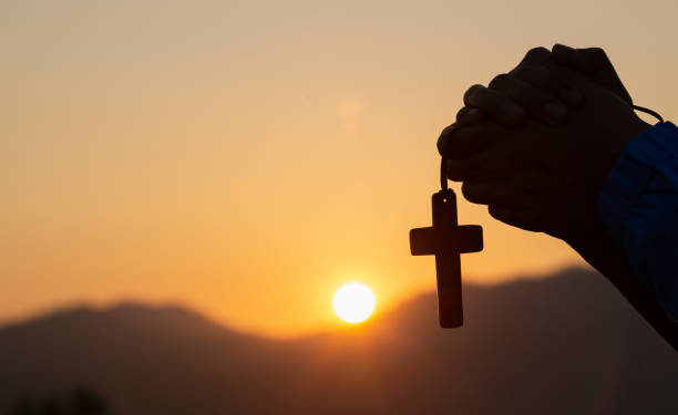 Christian woman praying on holy cross in the morning, teenager woman hand with cross praying,Hands folded in prayer in church concept for faith, spirituality and religion