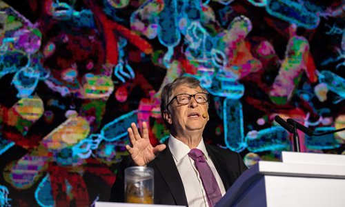 Microsoft founder Bill Gates (R) talks next to a container (L) with human feces during the "reinvented toilet expo" in Beijing on November 6, 2018. (Photo by Nicolas ASFOURI / AFP)