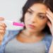 pregnancy, fertility, maternity and people concept - close up of sad unhappy woman looking at home pregnancy test