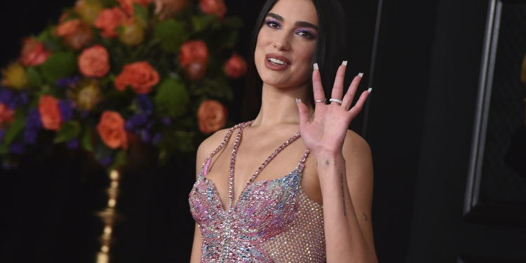 FILE - In this Sunday, March 14, 2021 file photo, Dua Lipa arrives at the 63rd annual Grammy Awards at the Los Angeles Convention Center. British music's leading prize night next month will feature an audience of 4,000 people, in what will be the first major indoor music event in the country to welcome back a live audience since the coronavirus pandemic erupted more than a year ago. “This has been a long tough year for everyone and I’m delighted the night will honor the key worker heroes who have cared for us so well during that time and continue to do so,” said singer/songwriter Dua Lipa, who is set to perform at the event. (Photo by Jordan Strauss/Invision/AP, File)