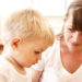 mother talking with her unhappy son at home; shallow DOF, focus on mothers eyes