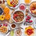 Happy breakfast with granola, croissant, fresh waffles, fruits and berries.