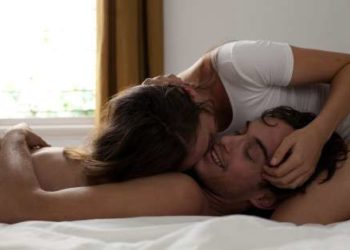 Couple in bed laughing and cuddling