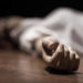 The dead woman's body. Focus on hand