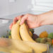 Woman getting fresh bananas from a fridge. Close up.