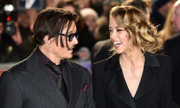 US actor Johnny Depp (L) jokes with fiancee US actress and model Amber Heard (R) as they arrive for the UK premiere of the film 'Mortdecai' in London on January 19, 2015.  AFP PHOTO / LEON NEAL        (Photo credit should read LEON NEAL/AFP/Getty Images)