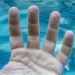 The photo palm child of three years , which wrinkled and shriveled due to the long stay in the water and swim , pink palm on a white background. (The photo palm child of three years , which wrinkled and shriveled due to the long stay in the water and