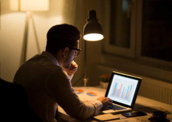 Man working with laptop late at night at home