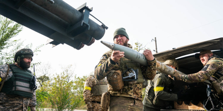 A group of Ukrainian soldiers load a rocket under the voer of trees in Kherson Region. The approaching winter may force a change in tactics, Ukrainian military units and Western military analysts say.