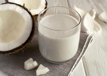 Coconut  milk in the drinking on the white background. Close-up.