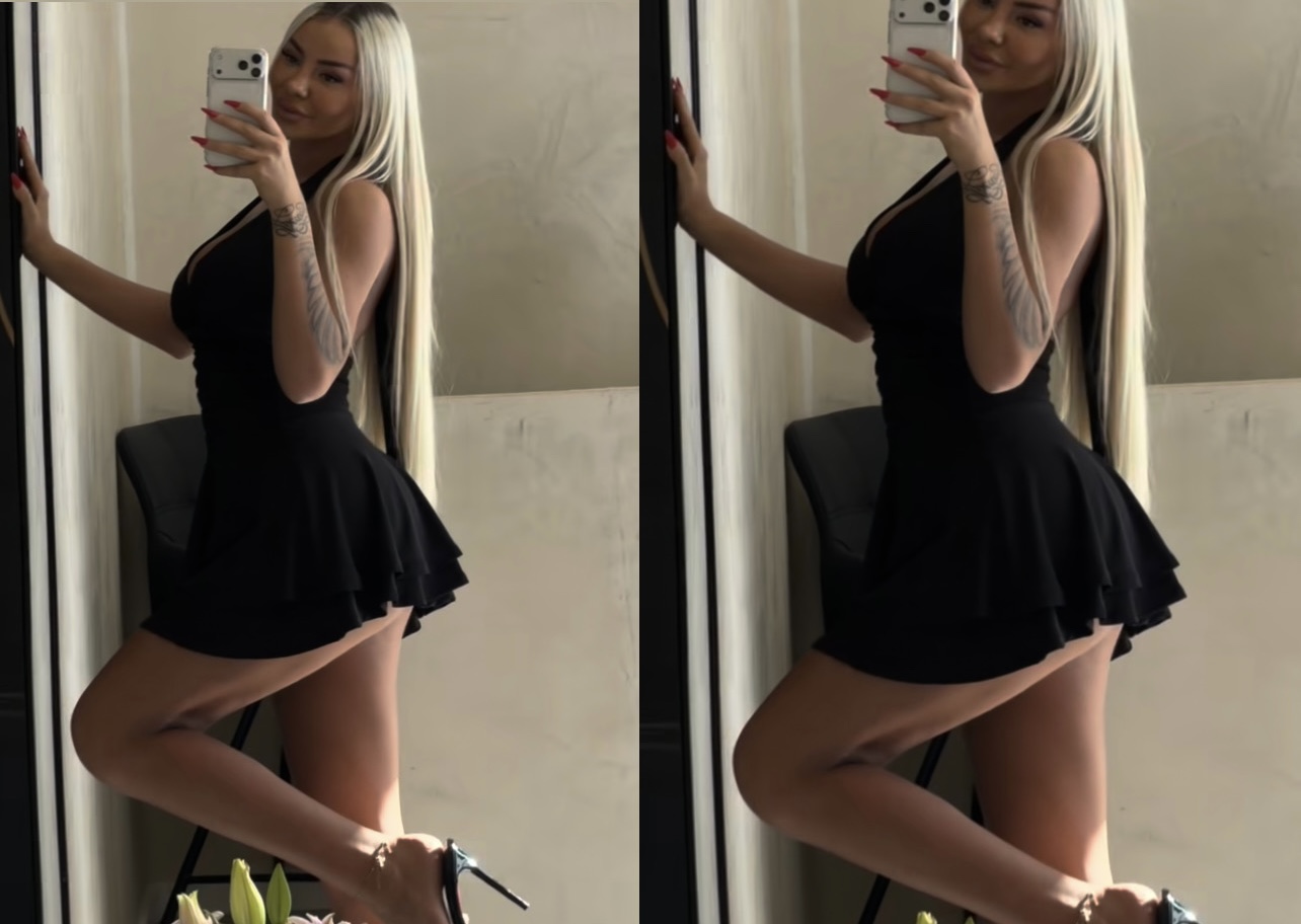 Benita me fustan të shkurtë  i qet të pasmet  në fushë 